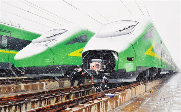 北京库检车间职工顶风冒雪检修动车组列车